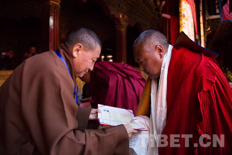 图为中国佛教协会西藏分会会长珠康·土登克珠活佛向荣获格西拉让巴